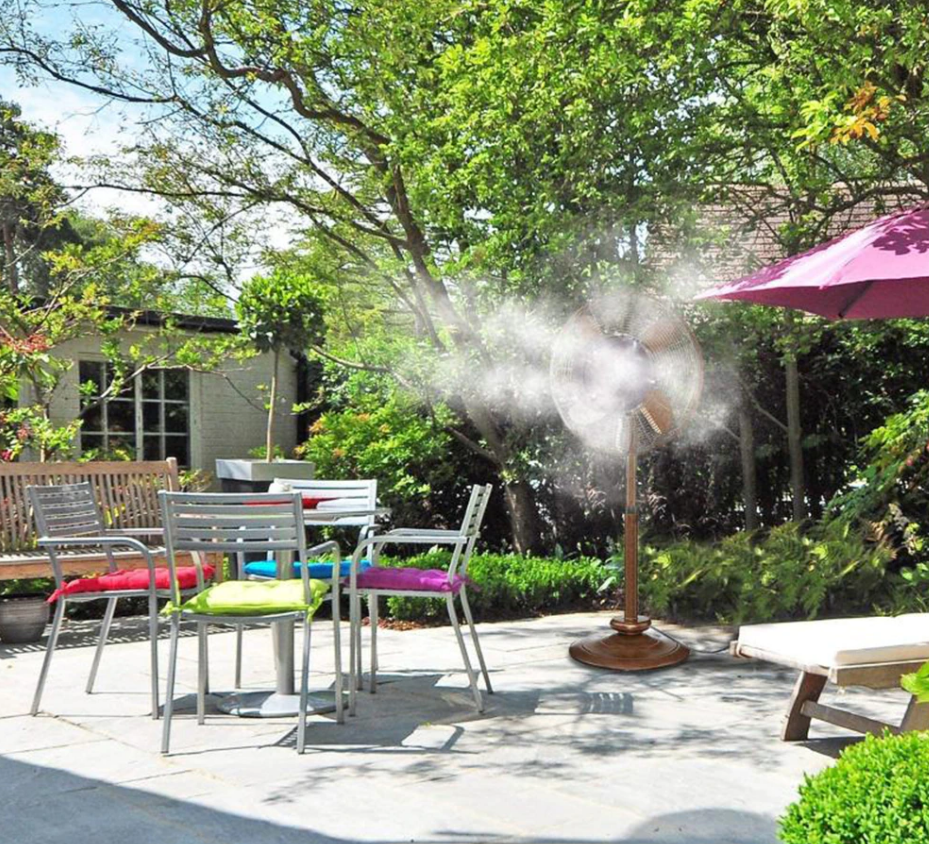 tuin met ventilator die koele water nevel verspreid